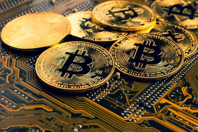 Picture of gold bitcoins on top a circuit board